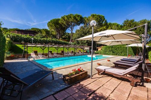 una piscina con sombrillas y tumbonas junto a ella en Casal Toscano, en Casale Marittimo