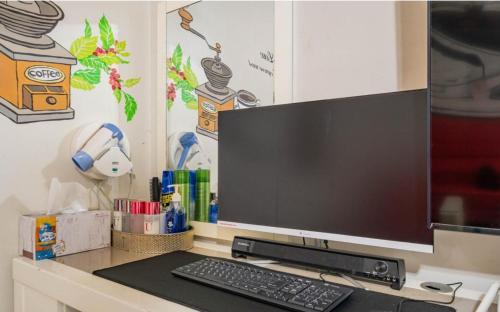 a computer monitor sitting on a desk with a keyboard at Empire Motel in Cheonan