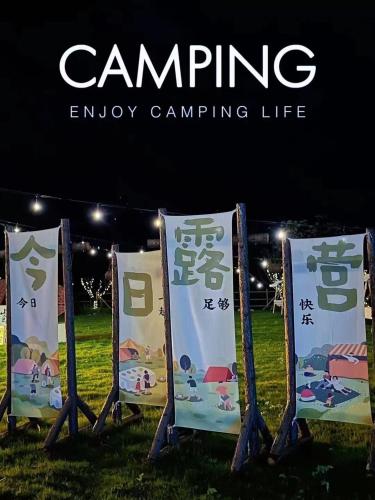 a group of signs sitting in the grass at Zhangjiajie Cliff Flower RV Tent Hotel in Sanguansi
