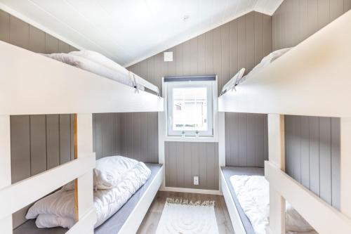 a room with three bunk beds and a window at Ballangen Camping in Narvik