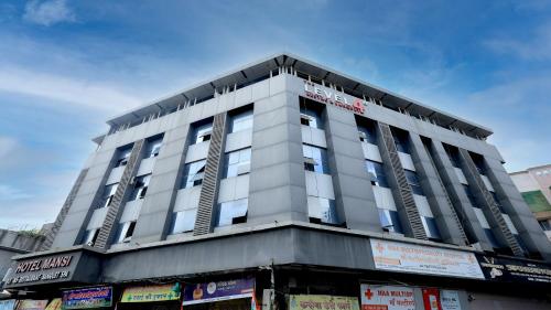 a tall white building with a lot of windows at Hotel Mansi in Vapi