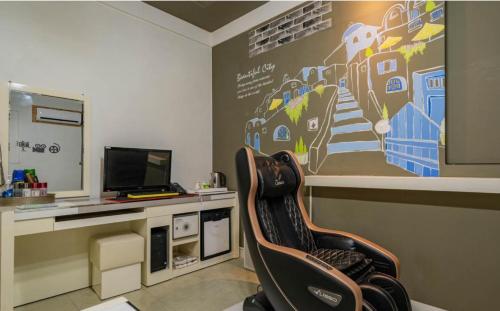 a chair in a room with a desk with a computer at Empire Motel in Cheonan