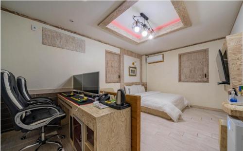 a hotel room with a bed and a desk with a computer at Empire Motel in Cheonan