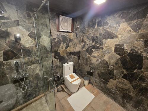 a bathroom with a toilet and a glass shower at Ceylon Resort Wilpattu in Wilpattu