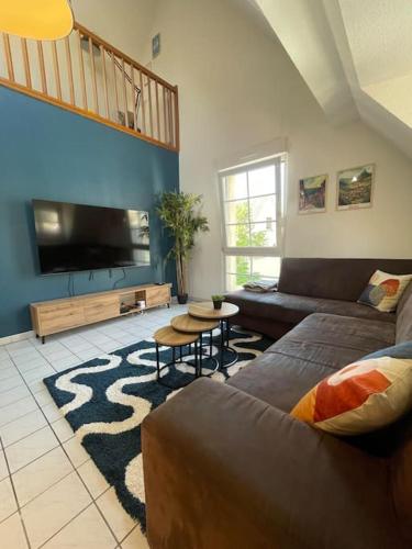 un salon avec un canapé et une télévision à écran plat dans l'établissement Appartement cosy au centre-ville avec garage, à Sélestat