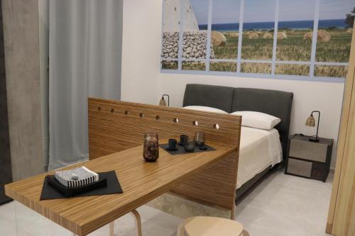 a bedroom with a bed and a wooden table at Ringo Suites in Grumo Appula