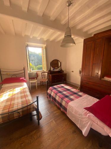 une chambre avec deux lits et une fenêtre dans l'établissement Appartamento Rustico nel centro storico, à Urbania