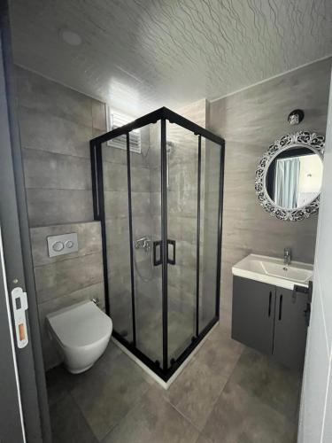 a bathroom with a shower and a toilet and a sink at Mersin Panorama Otel in Kargipınarı
