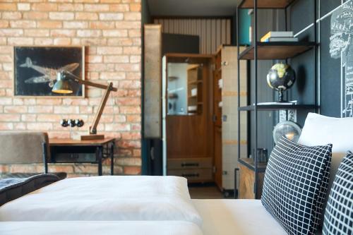 a room with a bed and a brick wall at Fliegerdeich Hotel & Restaurant in Wilhelmshaven