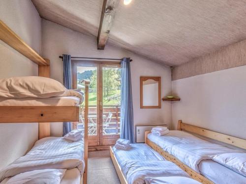 deux lits superposés dans une chambre avec fenêtre dans l'établissement Bel appartement au pied des pistes-Megeve, à Demi-Quartier