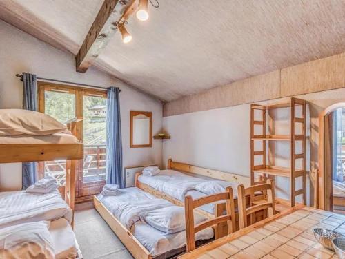 une chambre avec trois lits superposés et une table dans l'établissement Bel appartement au pied des pistes-Megeve, à Demi-Quartier