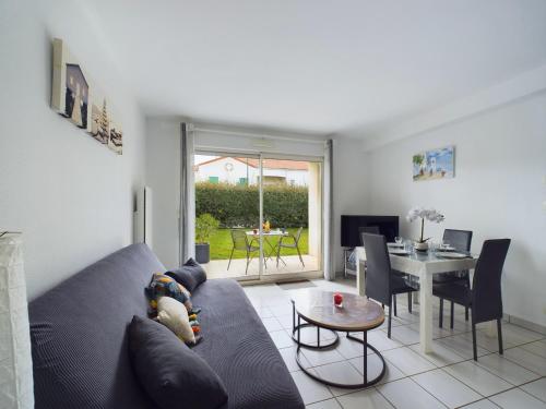 un salon avec un canapé et une table dans l'établissement Les Sables d'Olonne - appartement pour 4 et jardin, à Les Sables-dʼOlonne
