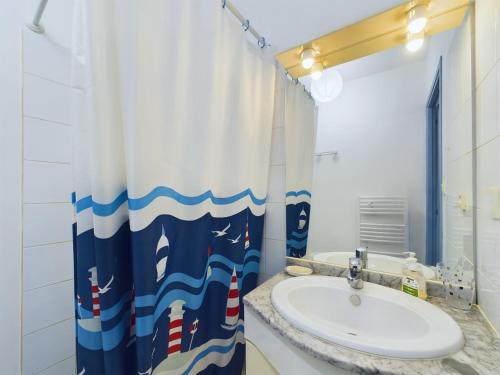 une salle de bain avec un lavabo et un rideau de douche dans l'établissement Les Sables d'Olonne - appartement pour 4 et jardin, à Les Sables-dʼOlonne