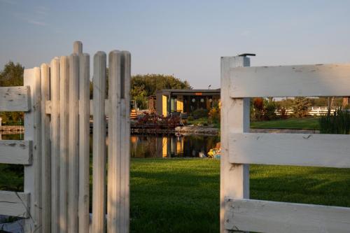 a white fence in front of a yard at Lisi Ogon zanurzeni w naturze in Lisi Ogon
