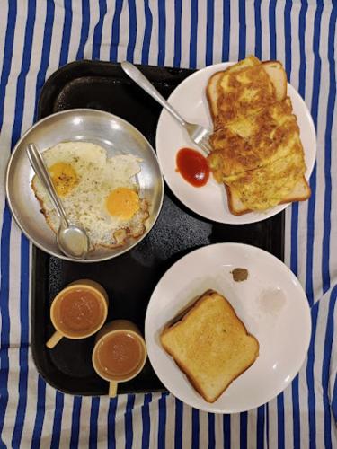 three plates of breakfast food on a table at Hotel Cosy Inn in Digha