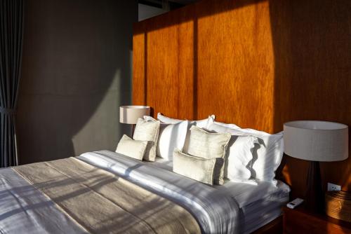 a bedroom with a bed with white sheets and pillows at Amaya Kampot Homestays in Kampot