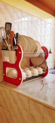 a kitchen counter with a shelf with pans and utensils at Salash apartments in Nairobi