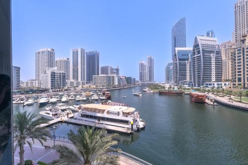 a large boat docked in a river in a city at Free housekeeping visits during your stay - StayShort - Elegant 3-Bedrooms in Dubai Marina with stunning views! in Dubai