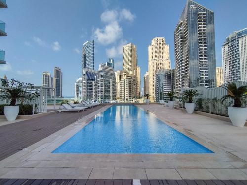 a large swimming pool in a city with tall buildings at Free housekeeping visits during your stay - StayShort - Elegant 3-Bedrooms in Dubai Marina with stunning views! in Dubai