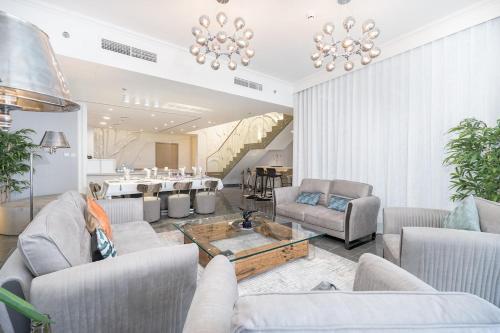 a large living room with couches and a table at Free housekeeping visits during your stay - StayShort - Elegant 3-Bedrooms in Dubai Marina with stunning views! in Dubai