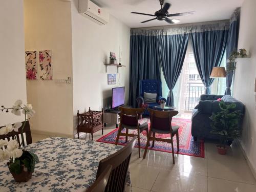 a living room with a table and chairs and a couch at Casarozza Homestay, Southville City in Bangi