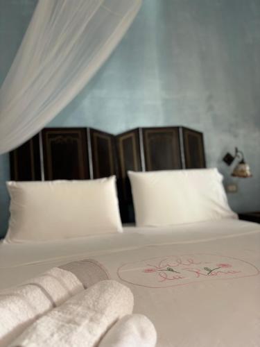 a bed with white sheets and white pillows at Villa La Rosa in Filicudi