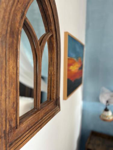 a mirror hanging on a wall next to a picture at Villa La Rosa in Filicudi