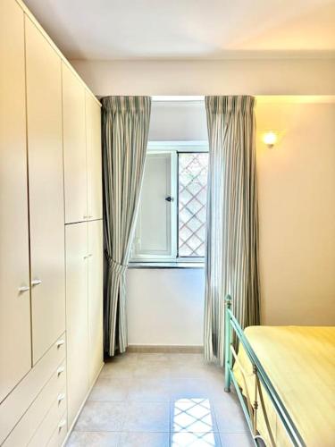 a bedroom with a bed and a window at Thalè - casa vacanza in Montepaone Lido