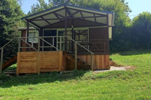 un petit bâtiment dans un champ d'herbe dans l'établissement le chalet de la source, à Saint-Sylvain