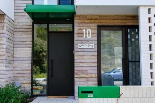 a building with a black door and a sign on it at Welcome to Whale Song in Albany