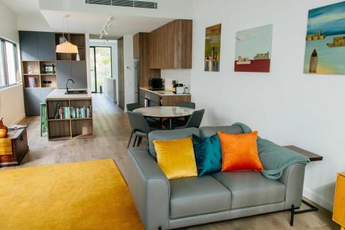 a living room with a couch with colorful pillows at Welcome to Whale Song in Albany
