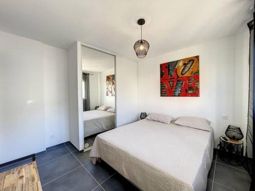 une chambre avec un lit et un miroir dans l'établissement Magnifique T2 vue sur la baie de Calvi, à Calvi