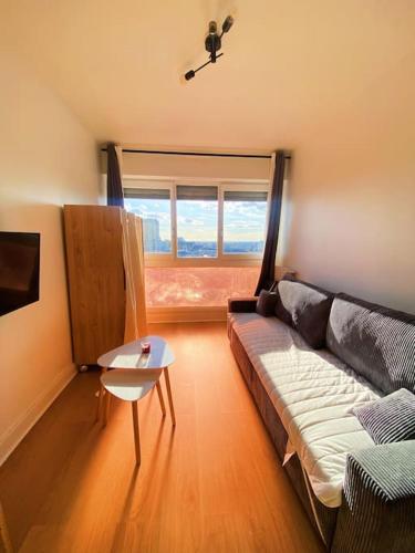 un salon avec un canapé et une fenêtre dans l'établissement Le cockpit, à Paris