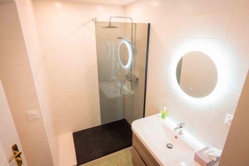 une salle de bain blanche avec un lavabo et un miroir dans l'établissement Appart 3 Grand 2 pièces en plein centre avec place de parking, à Aix-les-Bains