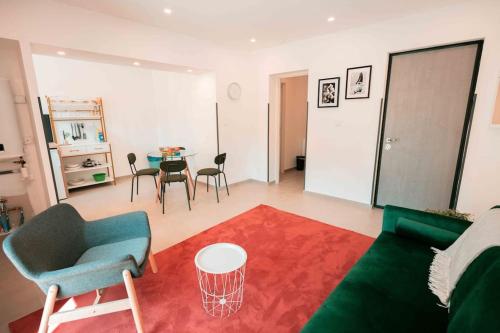 un salon avec un canapé vert et une table dans l'établissement Appart 3 Grand 2 pièces en plein centre avec place de parking, à Aix-les-Bains