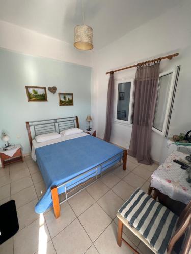 a bedroom with a blue bed and a chair at Hotel Glaros Lipsi in Lipsoi