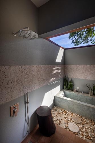 a bathroom with a tub and a toilet and a window at Amaya Kampot Homestays in Kampot