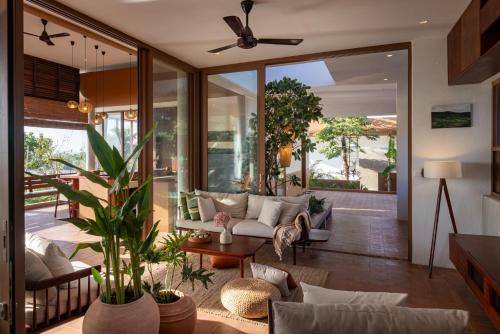 a living room with a couch and a ceiling fan at Amaya Kampot Homestays in Kampot