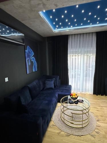 a living room with a blue couch and a table at TULUM luxury suites-SKOPJE in Skopje