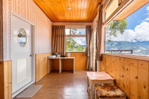a room with a balcony with a table and a window at Cingjing Star Lohas Manor B&B in Renai