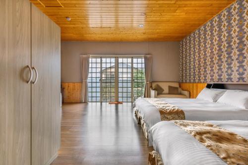 a bedroom with two beds and a wooden ceiling at Cingjing Star Lohas Manor B&B in Renai