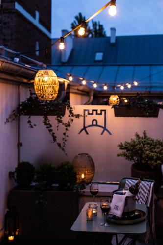a patio with a table with wine glasses and lights at Pokoje Gościnne WIDNOKRĄG in Sandomierz