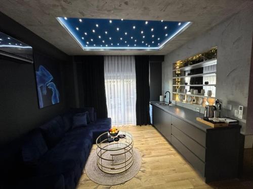 a living room with a blue couch and a table at TULUM luxury suites-SKOPJE in Skopje