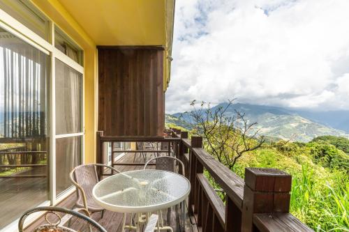a patio with a table and chairs on a balcony at Cingjing Star Lohas Manor B&B in Renai
