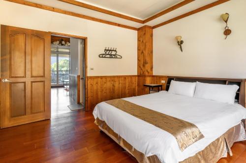 a bedroom with a large bed and a wooden floor at Cingjing Star Lohas Manor B&B in Renai