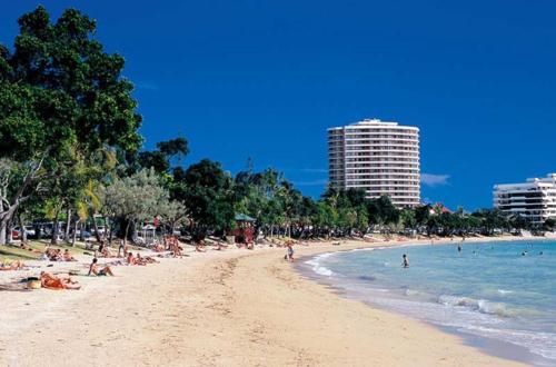 a beach with people laying on the sand and the ocean at À 50m de la plage et des bars de la baie des Citrons in Noumea
