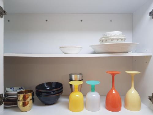 a row of colorful vases sitting on a shelf at Gangnam Yeoksam Station Full-option Remodeling New House in Seoul