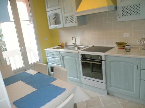 une cuisine avec des armoires bleues, un évier et une table dans l'établissement Noisette, à Menton