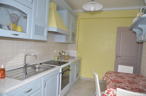 - une cuisine avec des placards blancs, un évier et une table dans l'établissement Noisette, à Menton