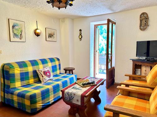 ein Wohnzimmer mit Sofa und Fernseher in der Unterkunft Cozy Three-Room Apartment with Mountain View & Parking - Ussin Chalet - Valtournenche in Chamois
